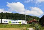 BLS  MUTZ (Serie 515) der S-Bahnlinie Bern - Schwarzenburg: Zug 515 018 fährt an der Blumenpracht eines dortigen Bauernhauses in ausserordentlich altem Baustil vorbei.