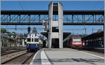 BLS Blauer Pfei und RE 460 - dazu der moderne Bahnhof von Spiez als Hintergrund.