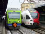 BLS / tpf - Triebzug RAe 525 019-6 als RE nach Bern und Triebzug RABe 527 195-7 als S20 nach Fribourg im Bahnhof Neuchâtel am 07.02.2015