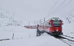 Mit dem Bernina-Express durchfährt der ABe 8/12 3501 am 03.04.2022 Bernina Lapalp, hinter dem Triebwagen die Panoramawagen.