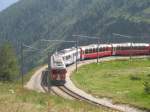 Hier der Bernina Express kommend aus Tirano, zur Weiterfahrt nach Chur, bei der Einfahrt am 24.7.2009 in Alp Gr�m.