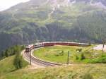 Hier ein Bernina Express nach Chur, bei der Einfahrt am 24.7.2009 in die Station Alp Gr�m.