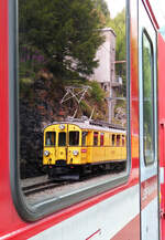 Spiegel-Triebwagen: im Fenster des Bernina-Express spiegelt sich der alte Bernina-Triebwagen ABe 4/4 30. Alp Grüm, 7.8.2025