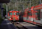 Am 06.09.2024 begegnen sich im Bahnhof Grengiols alt und neu. Die Front des Steuerwagens spiegelt sich in den Fenstern des Komet.