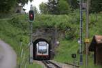 Am 26.05.2024 verschwindet der Panoramaexpress Luzern - Interlaken im kurzen Tunnel bei der Station Chräbel.