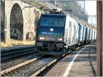 Die RTS Re 185 570-9 fährt mit ihrem Güterzug bei der Haltestelle Veytaux-Chillon durch.