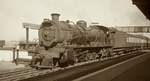 Eine Class 12R der South African Railways im November 1976 vor einem Vorortzug im Bahnhof Port Elizabeth.