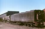 Dampf und Diesel in der Karoo: Blick auf den Tender einer Kondenslokomotive der Class 25 im November 1976 im Depot De Aar. Die Karoo, eine Halbwüste, nimmt etwa 1/3 der Fläche Südafrikas ein. Die Wasserversorgung der Dampflokomotiven bereitete hier stets Probleme. Um Abhilfe zu schaffen, bestellte die SAR bei Henschel und North British 90 Kondenslokomotiven, bei denen der Abdampf dem Tender wieder zugeführt wird. Im Vergleich mit konventionellen Dampflokomotiven konnte der Wasserverbrauch um etwa 85% gesenkt werden. Bis auf 3 wurden die 1954/54 in Dienst gestellten Kondensmaschinen ab 1974 wegen der fortschreitenden Elektrifizierung und Verdieselung zu 25 NC (=  non condens ) umgebaut.