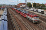 751 192 mit Autos geladen aus Richtung Zilina hält in Leopoldov am 5 September 2026 und von der Fussgängerbrücke aus fotografiert.
