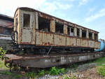 Ein restaurationsbedürftiger Schmalspur-Personenwagen, Klasse III auf einem Normalspur-FLachwagen. (Eisenbahnmuseum Ljubljana, August 2019)