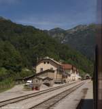 Einfahrt in Podbrdo, Bahnhof am Sdportal des Wocheinertunnels (Im Hintergrund zu erkennen).