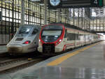 Renfe 211M mit C1 nach Jerez de la Frontera neben einem Alvia nach Madrid in Cadiz, 15.06.2021.