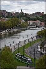 CAF Tram beim Guggenheim Museum am Ufer des Nervión mit der Fussgängerbrücke von Santiago Calatrava.