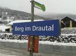 Bahnhofsschild Berg im Drautal und gleich daneben die Bushaltestelle Berg im Drautal Bahnhof.
