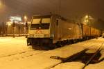 185 674-9 von TXLogistik steht am 28.1.2012 bei Winterlichem Wetter mit defekten Sattelauflegern Sgns im Bahnhof Kufstein.