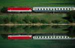 Auf der alten KBS 800 ist am 4. Oktober 1991 die BB-Ellok 1044 216 im km-Ausgleich fr 103-Durchlufe bis Wien-Westbahnhof mit EC 28  Prinz Eugen  soeben aus Wrzburg Hbf abgefahren und passiert einen Fischteich bei Thngersheim am Main in Richtung Frankfurt am Main