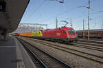 Mittwoch den 31.01.2024 um 13:43 Uhr in Buchs (SG). Im Bahnhof Buchs SG steht ein Abfahrbereiter Güterzug welcher ein Ziel in Österreich hat. Als Zugpferde dienen zwei Taurus Lokomotiven (bei den ÖBB tragen die Lokomotiven dieses Typs den geschützten Namen  Taurus“, das lateinische Wort für Stier – der mythologische Stier ist ein Symbol für Kraft). Vorne ist die rote Lokomotive (ohne Werbung) mit der UIC Nummer 91 81 1116 194-2 A-ÖBB. Hinten ist die gelbe Lokomotive mit der UIC Nummer 91 81 1016 020-0 A-ÖBB welche eine Werbung trägt. Wenn man den QR-Code der Werbung einliest kommt man auf Handwerkerberufe aus dem Baugewerbe. Angaben zur roten (194-2) Lokomotive; Erbauer: Siemens, Typ: ES 64 U2, Fabriknummer: 20915, Antriebsform: Bo’Bo’ elektrisch, Baujahr: 2004, Länderzulassung: A, D, CZ, CH, Höchstgeschwindigkeit: 230 km/h. Angaben zur gelben (020-0) Lokomotive; Erbauer: Siemens, Typ: ES 64 U2, Fabriknummer: 20368, Antriebsform: Bo’Bo’ elektrisch, Baujahr: 2000, Länderzulassung: A, D, CH, CZ, Höchstgeschwindigkeit: 230 km/h. Die Lokomotiven bis zum Baujahr 2008  spielen“ beim Anfahren die Tonleiter (siehe unter: https://wien.orf.at/v2/news/stories/2863787/). Koordinaten GMS (Grad, Minuten, Sekunden): N 47° 10’ 7.0’’ O 9° 28’ 44.5’’