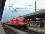 E-Lok 1116 258-3 fhrt mit ihrem langen Personenzug in den Hauptbahnhof von Innsbruck ein, vor der beeindruckenden Kulisse des Karwendelgebirges.