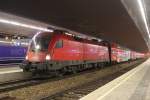 1116 184 vor dem R 2363 von Wien Floridsdorf (F) nach Payerbach-Reichenau (Pr), hier im Haltebahnhof Wien Meidling (Mi). Im Abgangn des Bahnhof spiegelt sich das Logo der Taurus; am 02.12.2011