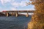 Herbst in Wien auf der Donauinsel: BR 1116 berquert mit einem Ganzzug das Entlastungsgerinne.