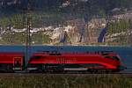 Railjet Lok 1116-217-1 Spirit of Switzerland fährt unter Schatten am windigen,föhngepeitschtem Walensee bei Mühlehorn vorbei an der Zugspitze des RJ von Zürich HB nach Wien