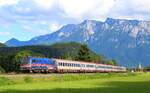 Vor Alpenpanorama präsentiert sich ein Eurocity mit populärer Taurus 1116 195  Nightjet  am 11.07.2021 bei Oberaudorf.