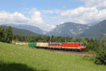 1144.117+1142.640 fahren mit G-54627 bei der Steinbauerwiese vor Rax und Schneeberg bei schöner Wolkenstimmung am Eichberg bergwärts.