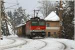 Teleaufnahme von der 1144 034, welche einen Schrottzug in Richtung Semmering zieht.