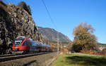 Bei goldenem Herbstwetter ist der 4024 058-2 der S-Bahn Tirol als Zug 5118 (S 1) von Kufstein nach Telfs-Pfaffenhofen unterwegs und passiert dabei die Wiesinger Steinwand kurz vor Jenbach, 10.11.2018.