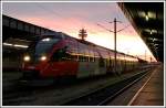 Triebwagen der Reihe 4024 bei Sonnenaufgang am Wiener Sdbahnhof - Ostseite am 9.12.2006. Im Hintergrund ist der Telekomturm zu sehen.