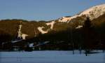 Der Verlauf der Standseilbahn im Schigebiet Rosshtte, aufgenommen von Seefeld aus, am halben Weg zwischen dem Billa und dem Bahnhof. Am Hang in der Abendsonne zur Linken erkennt man die gerade verlaufende Trasse, die sich dann nach rechts wendet und nach der langgezogenen Rechtskurve mit der Ausweiche wieder gerade verluft bis zur Bergstation, die zwischen zwei Waldstcken am Kamm herausragt. Dort ist auch die Talstation der Seilbahnen zum Seefelder Jchl (oben rechts zu sehen) und zum Hrmelekopf (zu unserer Rechten auerhalb des Bildes. Ende Jnner 2010 kHds - zweite, etwas hellere Variante um des Lieben Friedens Willen.