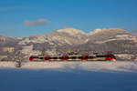 Vor der maleerischen winterlichen Bergkulisse Vorarlbergs fährt 4024 107-7 nach Dornbirn.