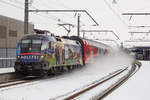 1116 157-9 als  Gemeinsam Sicher  Lok mit einem Dosto bespannt rauscht durch Dornbirn Schoren und wirbelt ordentlich Schnee auf.