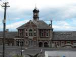 Die Fassade des Bahnhofgebaeudes von Muizenberg, soweit man dieses in der Enge ins Bild bekommt. Das Gebaeude steht unter Denkmalschutz ist jedoch seit einigen Jahren dem Zerfall frei gegeben. Will heissen, es wird kein Unterhalt gemacht und die eingemieteten Geschaefte sind auch nicht interessiert. Muizenberg, 20.11.2010