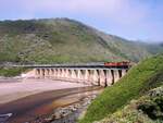 Die Kaaimans River Brücke bei Wilderness war die am meisten fotografierte Brücke Südafrikas, auf der täglich der Outeniqua Choo Tjoe von George nach Knysna als letzter regelmäßige Dampfzug Südafrikas verkehrte. 2006 zerstörten heftige Regenfälle, Erdrutsche und Überschwemmungen wichtige Teilstrecken zwischen George und Knysna, deren Instandsetzung zu teuer waren und dieses Teilstück daher früh außer Betrieb genommen wurde. Am 9.11.2000 fuhr unser Sonderzug mit Dieselloks der SAR Class 35-000, da wegen der Trockenheit keine Dampflok verkehren durfte.