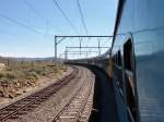 Am 20.11.2014 durchquert der Shosholoza Meyl nach Johannesburg durch die Halbwüste Karoo, die dem Zug auch den Namen Trans-Karoo-Express gegeben hat. Am Ende des Zuges erkennt man die beiden Gepäckwagen sowie den Autotransportwagen.