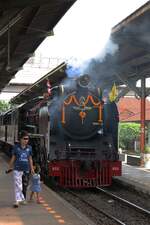 Ob das pfauchende Ding wohl ein schwarzer Drache ist? - Süß, wie die Kleine am 05.Dezember 2025 in der Chachoengssao Junction den Blick nicht von der 850 (2'C1'h2, Nippon Sharyo (Japan), Bauj. 1950, Fab.Nr. 1547) lassen kann.