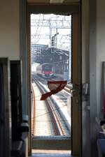 Blick durch die Stirnwandtüre des, als letzten Wagen des ORD 208 (Nakhon Sawan - Hua Lomphong) gereihten, บชส. 1184 (บชส. =BTC./Bogie Third Class Carriage) auf einen in der Lak Si Station der SRTET Red Lines (RN) haltenden Triebwagen der Type Hitachi AT100. - Bild vom 10.Dezember 2023.