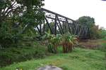 Von der 1978 eingestellten Bahnlinie Hat Yai Junction - Songkhla sind noch einige Relikte vorhanden. Ungefähr beim Strecken-Km 938 führt eine 60m lange Fachwerkbrücke über den Khlong Nam Noi. Bild vom 07.Jänner 2023 bei regnerischem Wetter.