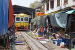 Strecken-KM 33,600, gleich beim Bf. Mae Klong am 27.März 2010. Der nummernlose Triebwagen verlässt die Bahnhofshalle und befährt die nun frei gegebene Strecke.