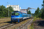 Am 15. August 2025 eilte die ČD 754.064 mit dem Schnellzug R 321  Silva Nortica  von Praha hl.n. nach Wien Franz-Josefs-Bahnhof durch den Bahnhof Nová Ves nad Lužnicí. Im Hintergrund gibt es etwas Industrie-Atmosphäre in Form des Werkes der Firma CEMIX. Dort werden die in einer nah gelegenen Sandgrube abgebauten Rohstoffe zu Mörtel verarbeitet. 
