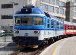 Farbenprächtiger Eilzug mit Dieseltriebwagen wartet im Bahnhof Brno hn.