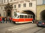 Wagen 8546 der Prager Straenbahn durchfhrt ein Haus am Křiovnick nměsti direkt an der Karlsbrcke (Karlův most).