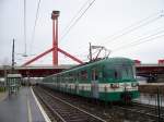 Triebzug 847 (andere Baureihe) der HEV-Linie Boraros ter - Csepel verlt am 20.01.2007 die Station Lagymanyosi hid, im Hintergrung die Lagymanyosi-Brcke ber Donau, die jngste der Budapester Donaubrcken.