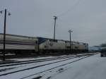 Amtrak 185 & 158 wait patiently on a snowy December day for eastbound passengers to load at Burlington, Iowa. In this very site on the closest track to the right is the same track where the old Injun Joe Zephyr was backed into the depot for its southbound trek to St. Louis, Missouri half-a-century ago. Train is pointing south now, and in less than one mile will be crossing the Mississippi River.