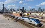 Der Amtrak-Zug 358  Wolverine Service  nach Toronto hat die Chicago Union Station vor wenigen Minuten verlassen, und wurde von mir am 27. April 2016 vor der imposanten Skyline der  Windy City  fotografiert.