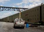 2.7.2012 Highland, NY. Ein Ganzzug mit Pkw unterquert die Poughkeepsie Railroad Bridge Richtung NY / NJ - heute ein State Park / Walk Way. Davor ein CSX-2Wege Fahrzeug. Bild zeigt sch�n die Dimensionen der Waggons ((Autoracks). Fahrleitung geht da wohl nicht mehr und L� Anton w�r gewiss auch �beschritten...:) 