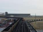 The loading tracks at the Thunder Basin Coal Company's Black Thunder Mine near Wright, Wyoming. This Sunday afternoon 10 Nov 2003 shows only 2 trains being loaded at the same time, one on far left and a BNSF on the third track from left while a Union Pacific veers off to right to loop around on a staging track. Speed limit for all trains is about 2 MPH.