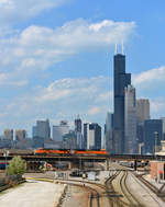 Vor der Kulisse des 527,3 Meter hohen Sears Towers (seit Juli 2009 Wills Tower) rollen die beiden BNSF EMD SD70ACe 9216  und 8448 mit einem Kohlezug über den Rail Road Yard 14th Street hinunter