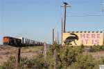 Ein Intermodal Zug, gezogen von den BNSF Loks # 6710 (GE ES44C4), 4183 (GE C44-9W) und 7886 (GE ES44DC), passiert das berhmte Hinweisschild des Jackrabbit Trading Post in Joseph City / Arizona  HERE